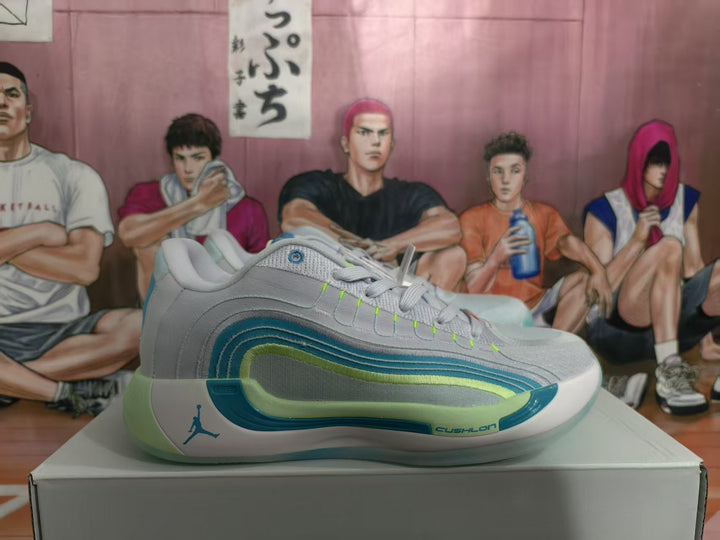 Side view of white Jordan sneakers with blue and green layered accents on a shoe box