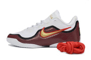 Side profile of a white, black and red Nike LeBron 23 basketball shoe with a gold-toned swoosh.