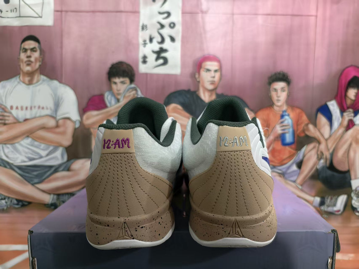 Rear view of white, blue, and tan Jordan 12-AM basketball sneakers showing the 12-AM heel markings and speckled midsoles.