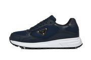 Side view of a navy lace-up sneaker with mesh panels, a triangular side plaque, white midsole and black outsole.