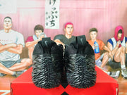 Rear view of black Nike shoes showing the heel details and angular speckled soles.