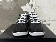 Front view of black Nike basketball shoes with white laces and raised patterned uppers