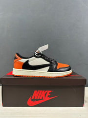 Side profile of a black, orange and white low-top sneaker on a branded shoebox.