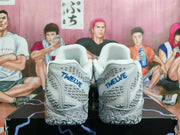 Rear view of grey and white Nike basketball shoes with blue heel lettering and patterned details.