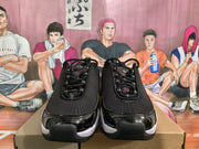 Front view of the black and white Nike sneakers showing the laces, textured toe area, and glossy toe overlays.