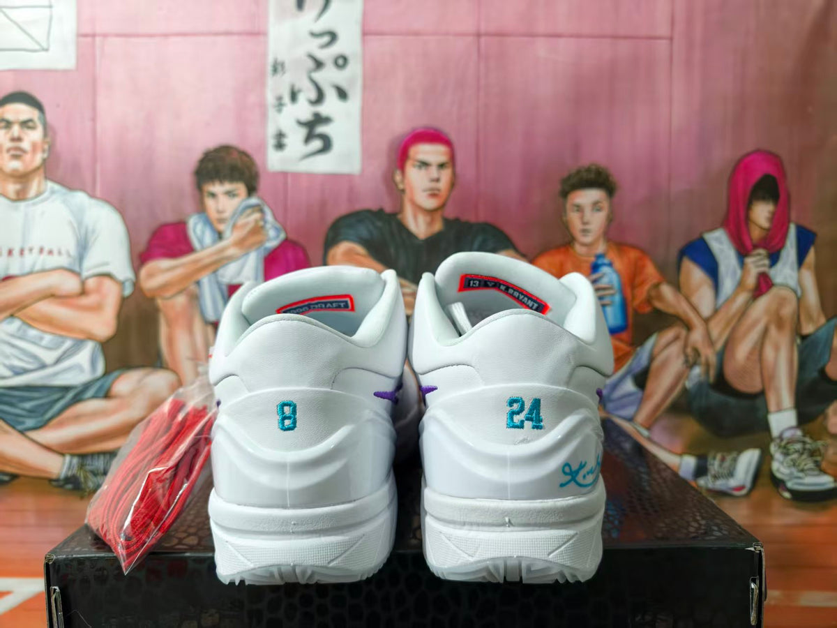 Rear view of white basketball shoes with teal heel numbers and purple accents.