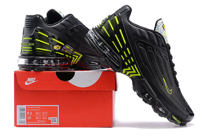 Black and volt Nike Air Max Plus sneakers displayed with a shoe box; the box label shows a sample size.