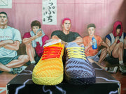 Front view of mismatched yellow and blue Nike basketball sneakers with red and yellow laces.