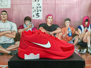 Side profile of a red sneaker with a white Swoosh, padded upper panels, and a red outsole.