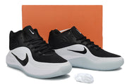 Black and white Nike basketball sneakers displayed in front of an orange shoe box.