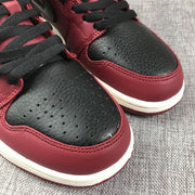 Close-up of the black perforated toe panels, burgundy trim, and black laces.