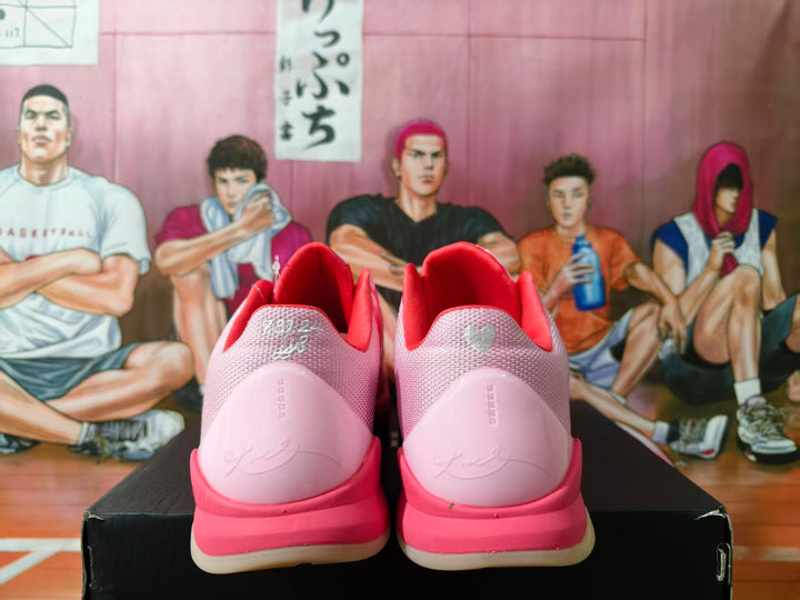Rear view of pink Nike sneakers with red collars and pale pink heel panels.