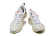 Pair of white Nike LeBron basketball shoes with red accents, shown from the front