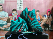 Pair of teal and black Nike basketball sneakers displayed on a shoebox, showing the patterned upper, contrasting Swoosh and black outsole.