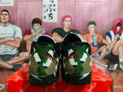 Rear view of military green camouflage basketball sneakers with red heel lettering, black collars, and textured black outsoles on a red box.
