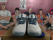 Front view of the white and navy ASICS shoes, showing the dark laces, textured tongues and rounded toe areas.