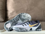 Nike Kobe 9 GiGi sneakers displayed with one outsole facing upward, showing a black-and-gray wavy traction pattern.