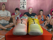 Front view of the mismatched pink and yellow sneakers with coordinating laces.