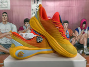 Angled view of the orange Curry basketball shoes showing the lace-up design, padded collar, textured toe area and sculpted outsole.
