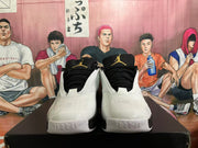 Front view of white and black Jordan sneakers showing black tongues, laces and Jumpman logos.