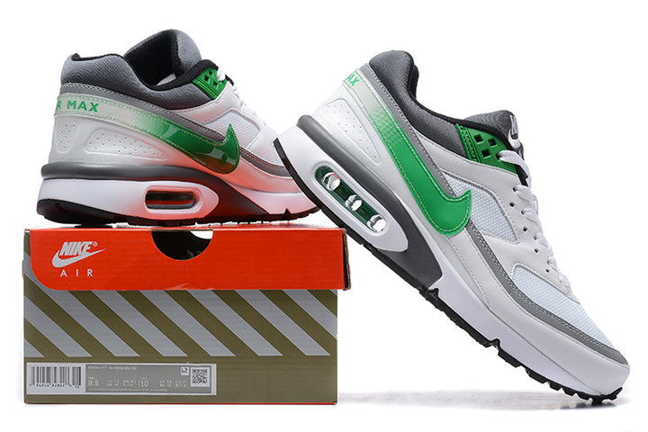 White and green Nike Air Max sneakers shown beside a branded shoe box; the box label shows a sample size.