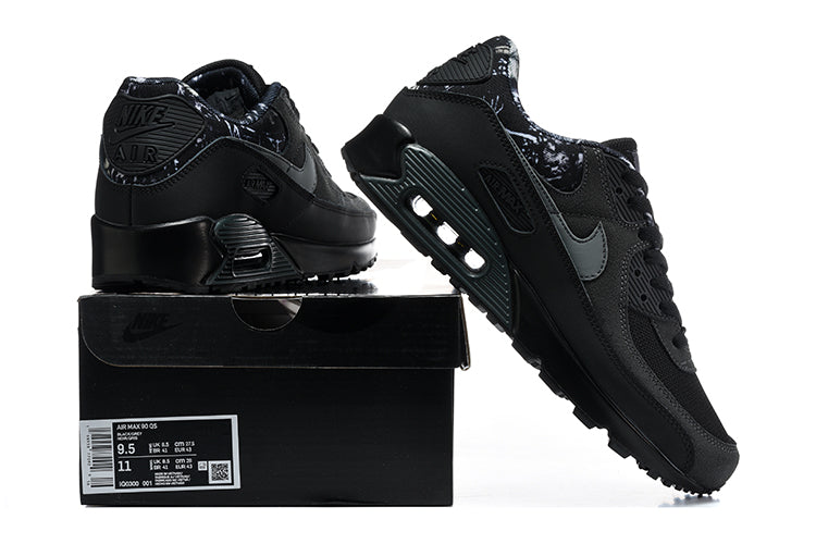 Black Nike Air Max 90 sneakers shown with a black shoe box; the box label shows a US Men’s 9.5 sample size.