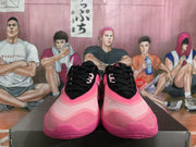 Front view of the black and pink Nike basketball sneakers showing black laces, pink overlays, and rounded toe boxes.
