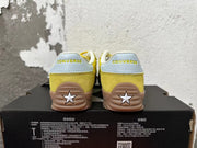 Rear view of yellow Converse training-style shoes with light-colored heel panels and gum-colored soles.