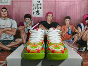 Front view of the pair showing the multicolor patterned toe boxes, white laces, red accents, and bright green outsoles.