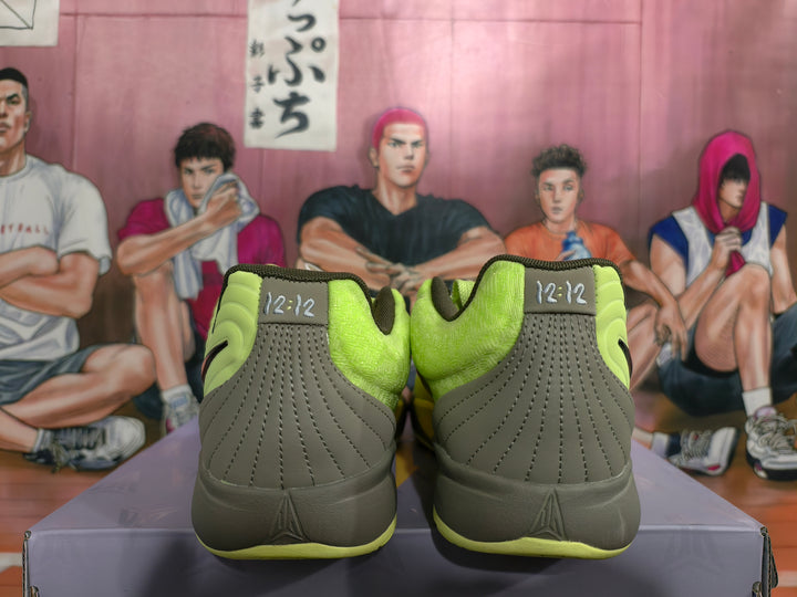 Rear view of neon green and dark gray Nike basketball sneakers with padded collars and orange accents.