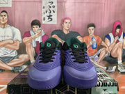 Front view of the black and blue adidas basketball sneakers with black laces and green tongue logos.