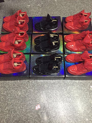 Top-down view of red and black high-top sneakers arranged around patterned boxes.