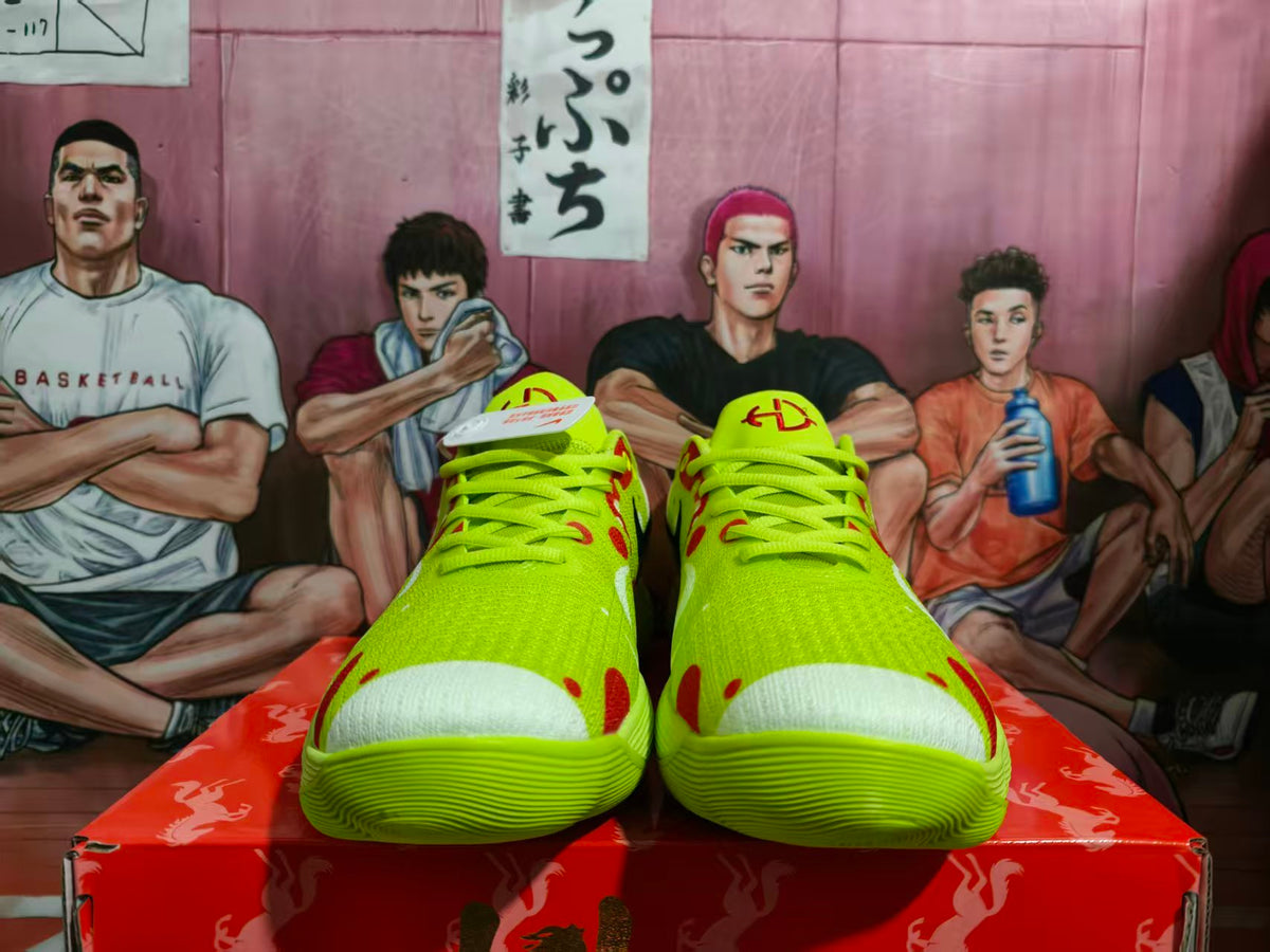Front view of bright yellow Nike sneakers with red and black accents, displayed on a red shoebox.