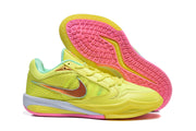 Yellow basketball shoes shown with the pink patterned outsole visible.