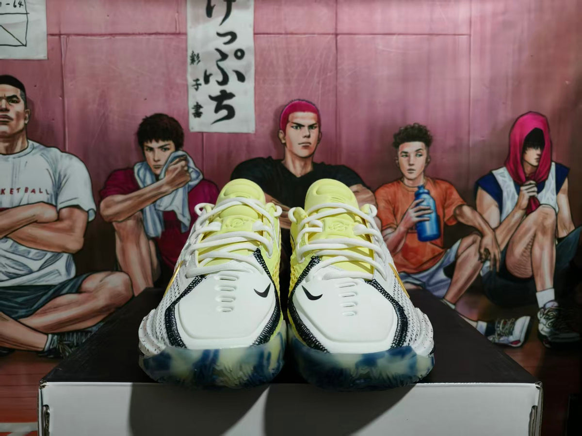 Front view of white Nike basketball shoes with yellow details, black swooshes, and blue-patterned soles.