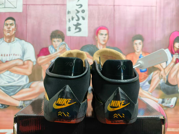 Rear view of black and metallic-gold Jordan basketball shoes with gold heel logos
