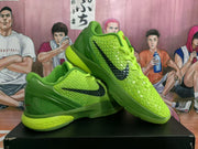 Side view of vivid green Nike basketball shoes showing black Swoosh logos and contrasting heel details.