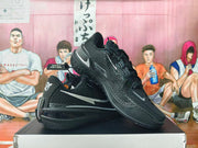 Angled view of black basketball shoes showing mesh-patterned sides, silver accents, and heel cushioning