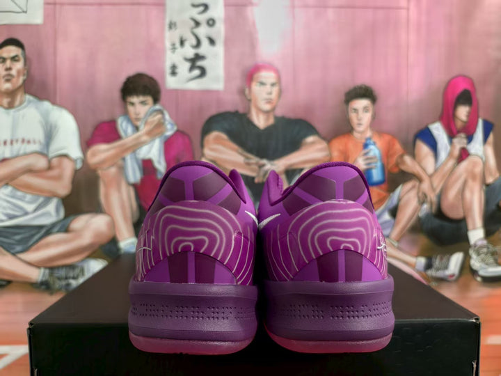 Rear view of purple Nike basketball sneakers displayed on a black box, showing tonal heel panels and decorative line details.