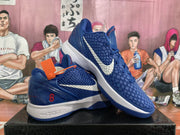 Angled view of the blue and white Nike basketball sneakers with textured uppers and contrasting Swooshes