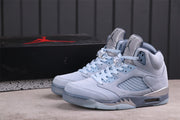 Three-quarter view of the pair displayed beside a black Jordan-branded shoebox.