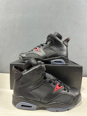 Side view showing the black upper, perforated panels, red lace-area accent, and translucent gray midsole section.