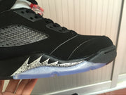 Close-up of the black toe and side area with silver speckled detailing above the translucent outsole.