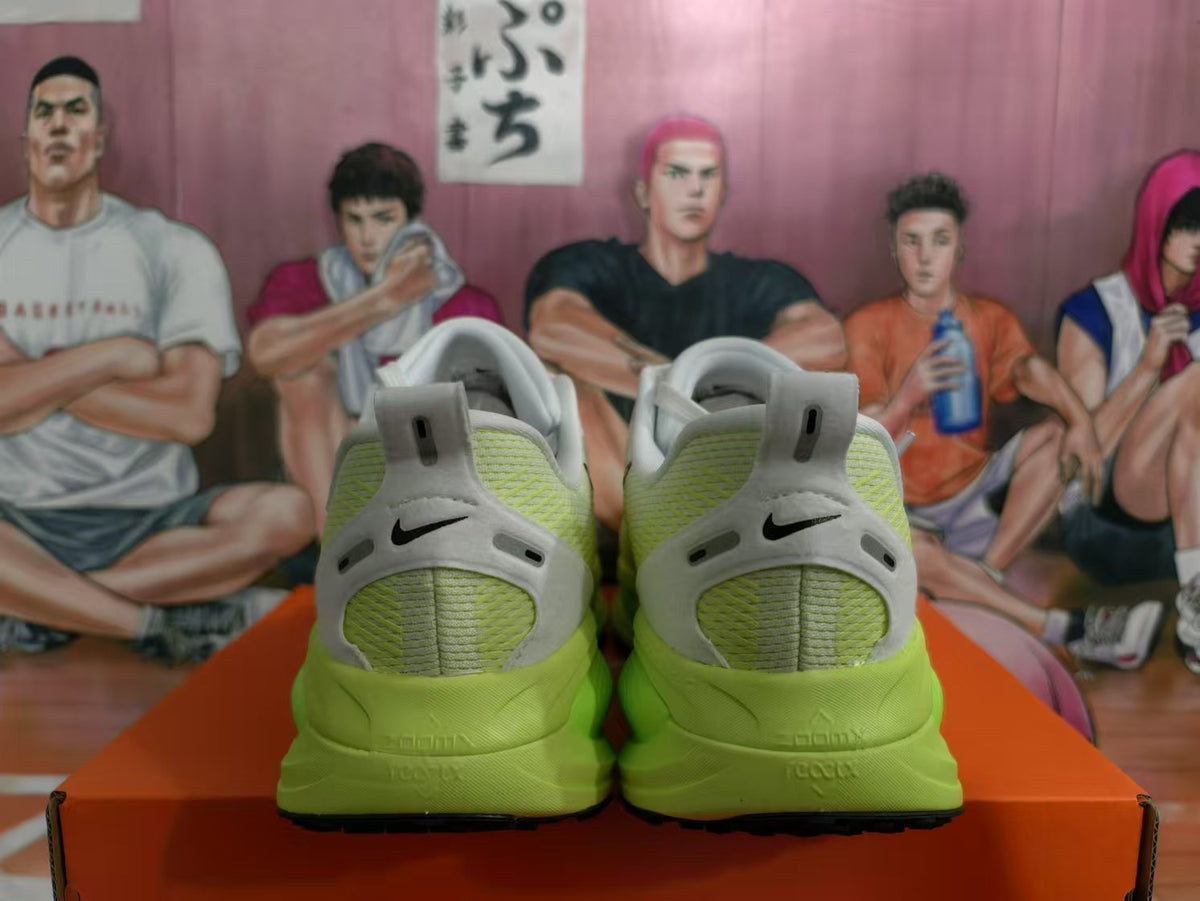 Rear view of green Nike sneakers showing black heel Swoosh details, white heel panels, and green soles.