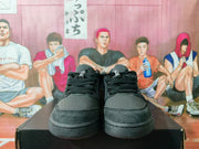 Front view of black lace-up sneakers with perforated toe panels