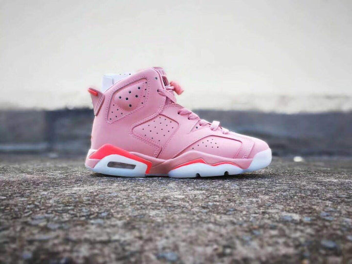 Side view of a pink Jordan Air Jordan 6 high-top sneaker with perforated panels and red midsole accents.