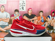 Side view of a red Nike basketball sneaker with a white Swoosh, navy accents, and a translucent-looking outsole.