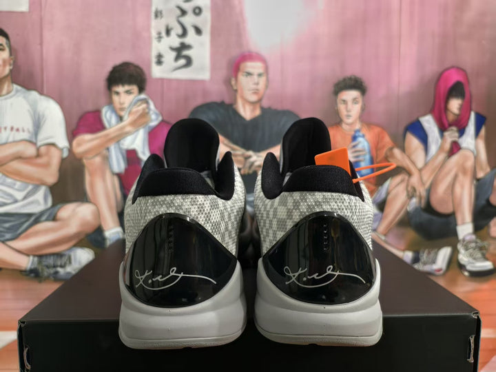 Rear view of grey patterned Nike basketball sneakers with glossy black heel panels and signature details.