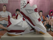 Pair of white and grey sneakers with red accents shown from the side