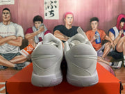 Rear view of light-colored Nike basketball shoes on an orange box